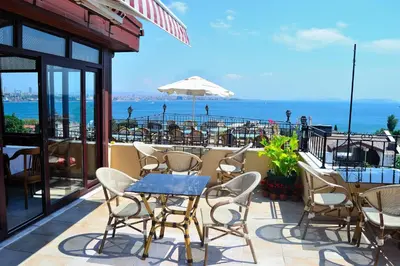 a patio with a table and chairs and the ocean at Hotel Alp Guesthouse in Istanbul
