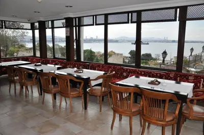 a restaurant with tables and chairs and a view of the water at Hotel Alp Guesthouse in Istanbul