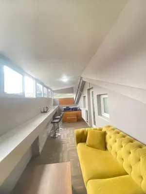 a living room with a yellow couch and a desk at Rena Apart Hotel in Istanbul