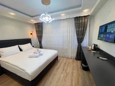 a hotel room with a bed and a chandelier at Feycem Suites Hotel in Istanbul