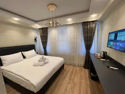 a hotel room with a bed and a television at Feycem Suites Hotel in Istanbul