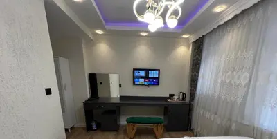 a room with a desk and a tv on a wall at Feycem Suites Hotel in Istanbul