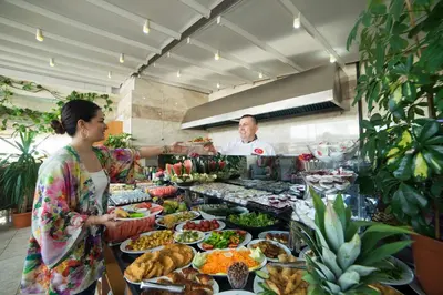 a woman standing in front of a buffet of food at Parmada Hotel in Istanbul