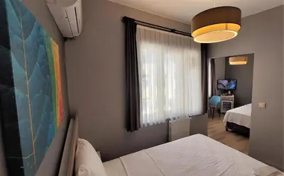 a bedroom with a bed and a window and a room with a bed sqor at Armoni City Otel Kadıköy in Istanbul