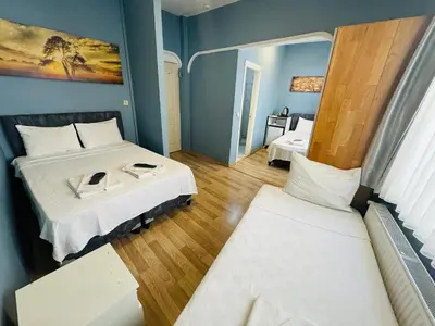 a small room with two beds and two windows at Armoni City Otel Kadıköy in Istanbul