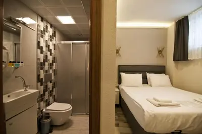 a bedroom with a bed and a bathroom with a shower at SULTAN SÜLEYMAN APART HOTEL in Istanbul