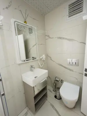 a white bathroom with a sink and a toilet at gazelle suites in Istanbul