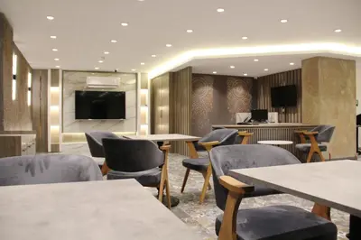 a restaurant with tables and chairs and a flat screen tv at Sabiha Sultan Hotel-Karakoy in Istanbul