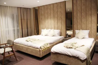 a hotel room with two beds with white sheets at Sabiha Sultan Hotel-Karakoy in Istanbul
