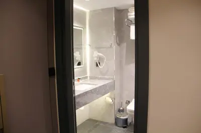 a bathroom with a sink and a mirror and a toilet at Sabiha Sultan Hotel-Karakoy in Istanbul
