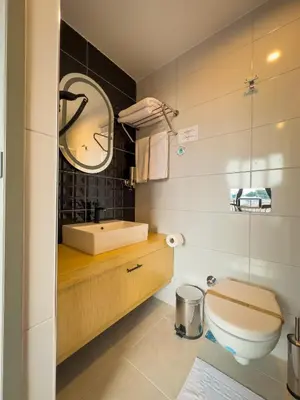 a bathroom with a toilet and a sink and a mirror at Mihman Hotel in Tuzla