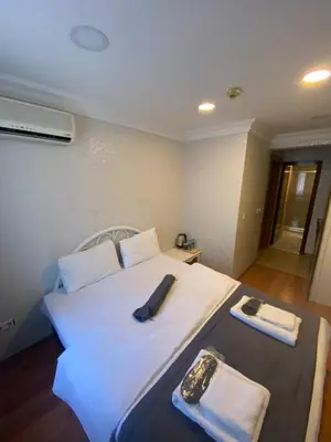 a bedroom with a large white bed with towels on it at Timex Suites in Istanbul