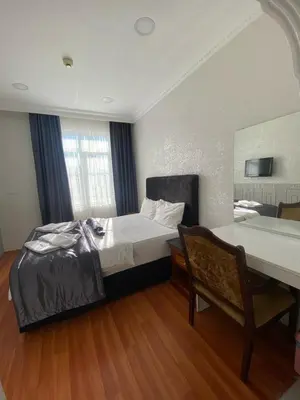 a bedroom with a bed and a table and a desk at Timex Suites in Istanbul