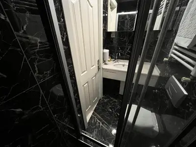 a black and white bathroom with a sink and a mirror at Gulhane Hotel Old City in Istanbul