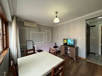 a living room with a table and a tv at Gulhane Hotel Old City in Istanbul