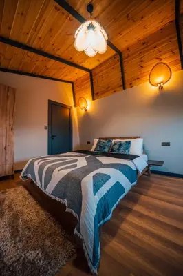 a bedroom with a large bed with a wooden ceiling at Vital Göl Sapanca Özel Havuzlu Bungalov & Villa in Sapanca