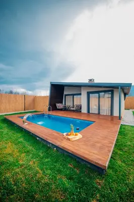 a backyard with a swimming pool and a wooden deck at Vital Göl Sapanca Özel Havuzlu Bungalov & Villa in Sapanca