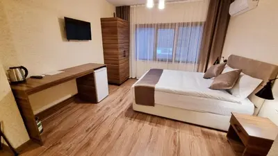 a bedroom with a bed and a desk and a television at La Pearl Konaklama in Istanbul