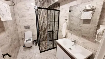 a bathroom with a white toilet and a sink at La Pearl Konaklama in Istanbul