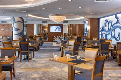 a dining room with tables and chairs and a screen at Anemon Bursa Otel in Bursa