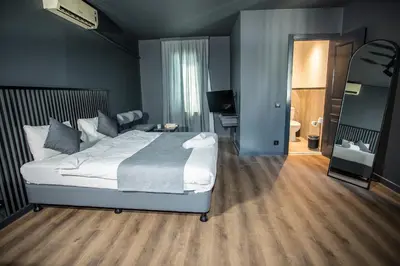 a bedroom with a large white bed and a desk at Arkem Deluxe in Istanbul