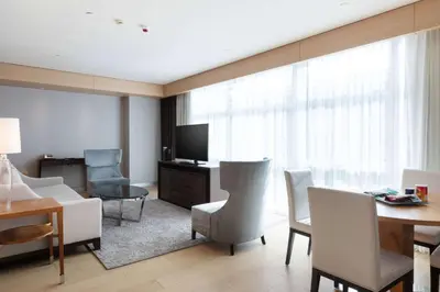 a living room with a table and chairs and a television at Wyndham Grand Istanbul Levent Hotel & Conference Center in Istanbul