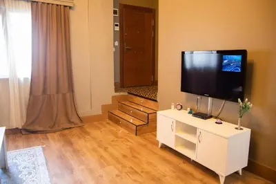 a living room with a flat screen tv on a white cabinet at The Hera Hotels in Istanbul