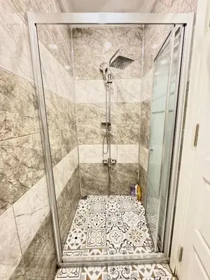 a shower with a glass door and a tiled floor at Central of İstanbul near to so many historic place in Istanbul
