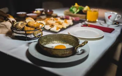 a breakfast table with a bowl of eggs and bread at Régie Ottoman Istanbul - Special Category in Istanbul