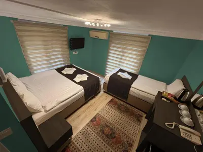 two beds in a room with green walls and a table at Le Safran in Istanbul