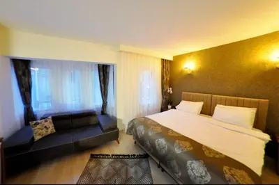 a hotel room with a large bed and a couch at Atlantik Butik Hotel in Tekirdag