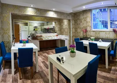 a kitchen and dining room with tables and blue chairs at Taksim Galata port BY AYDIN Apart - City Center in Istanbul