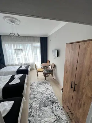 a hotel room with two beds and a table at Taksim Milenyum Suites in Istanbul