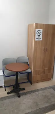 a table and a chair next to a wooden cabinet at Taksim Milenyum Suites in Istanbul
