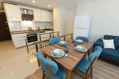 a kitchen and living room with a wooden table and chairs at Uzay Suite 1 in Istanbul