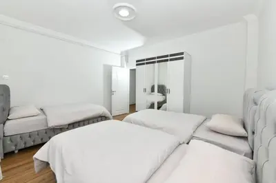 a white room with two beds and a mirror at Dilek Apartments in Istanbul