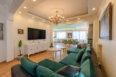 a living room with a green couch and a dining room at Dilek Apartments in Istanbul