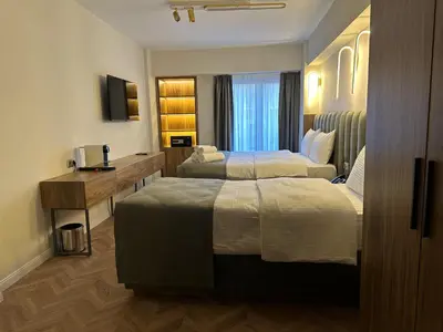 a hotel room with two beds and a desk at Iris Han Hotel in Istanbul
