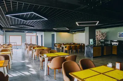 a dining room with yellow tables and chairs at N&D&D Hotel in Nilüfer