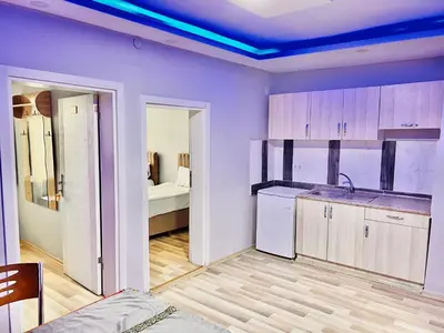 a kitchen with purple walls and a room with a bed at otel grand sami in Istanbul