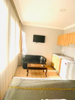a living room with a black leather chair and a couch at otel grand sami in Istanbul