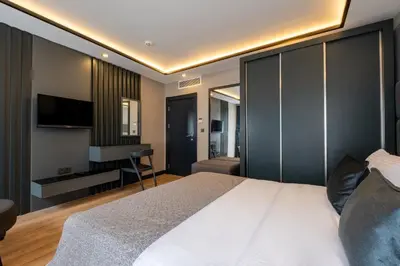 a bedroom with a bed and a desk and a television at The Row Suites Taksim in Istanbul