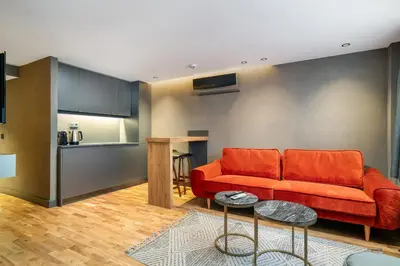 a living room with a red couch and a kitchen at Urban Quarters - Gülhane in Istanbul