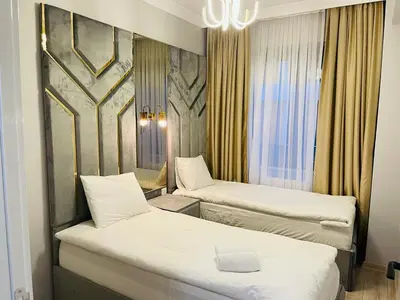a hotel room with two beds and a chandelier at Cantrmen Suites in Istanbul