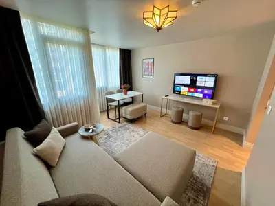a living room with a couch and a flat screen tv at Weingart Suites Hotel in Istanbul
