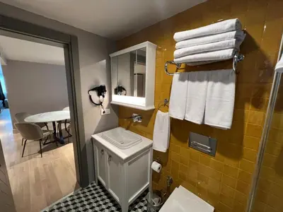a bathroom with a toilet and a sink and towels at Weingart Suites Hotel in Istanbul