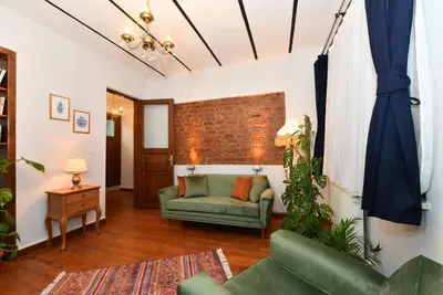 a living room with a green couch and a brick wall at Historical Levantine Flat @Heart of Taksim in Istanbul