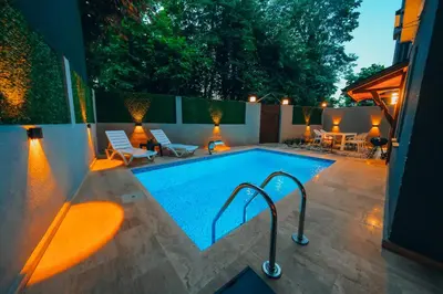a swimming pool with chairs and a table and a patio at Alphan House in Sapanca