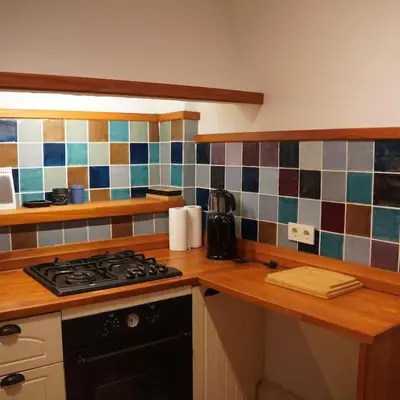 a kitchen with a stove and a tiled wall at GALATA KULESİ yakınında geniş 3+1 tarihi daire in Istanbul