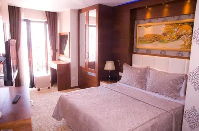 a bedroom with a bed and a painting on the wall at Kerimbey Hotel in Gemlik